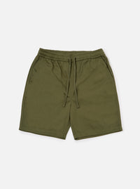 The Light Olive Twill Beach Short is shown as a flat lay against a plain white background. The shorts feature an elasticated waistband with a contrasting off-white drawstring, two front slant pockets, and a mid-thigh length. The garment is made from a solid light olive green cotton twill fabric.