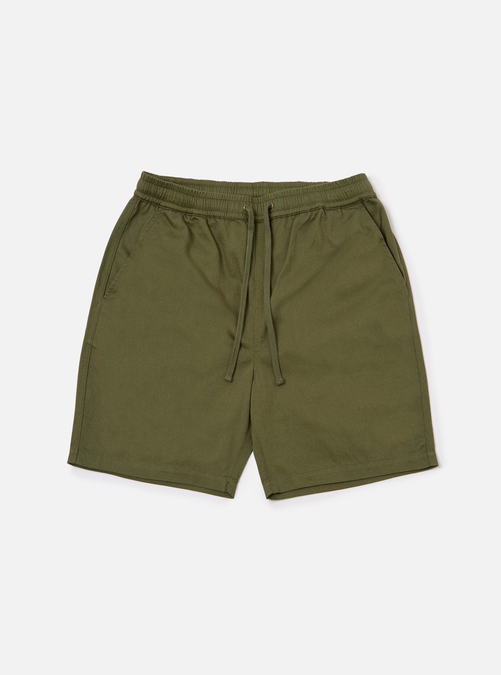 The Light Olive Twill Beach Short is shown as a flat lay against a plain white background. The shorts feature an elasticated waistband with a contrasting off-white drawstring, two front slant pockets, and a mid-thigh length. The garment is made from a solid light olive green cotton twill fabric.