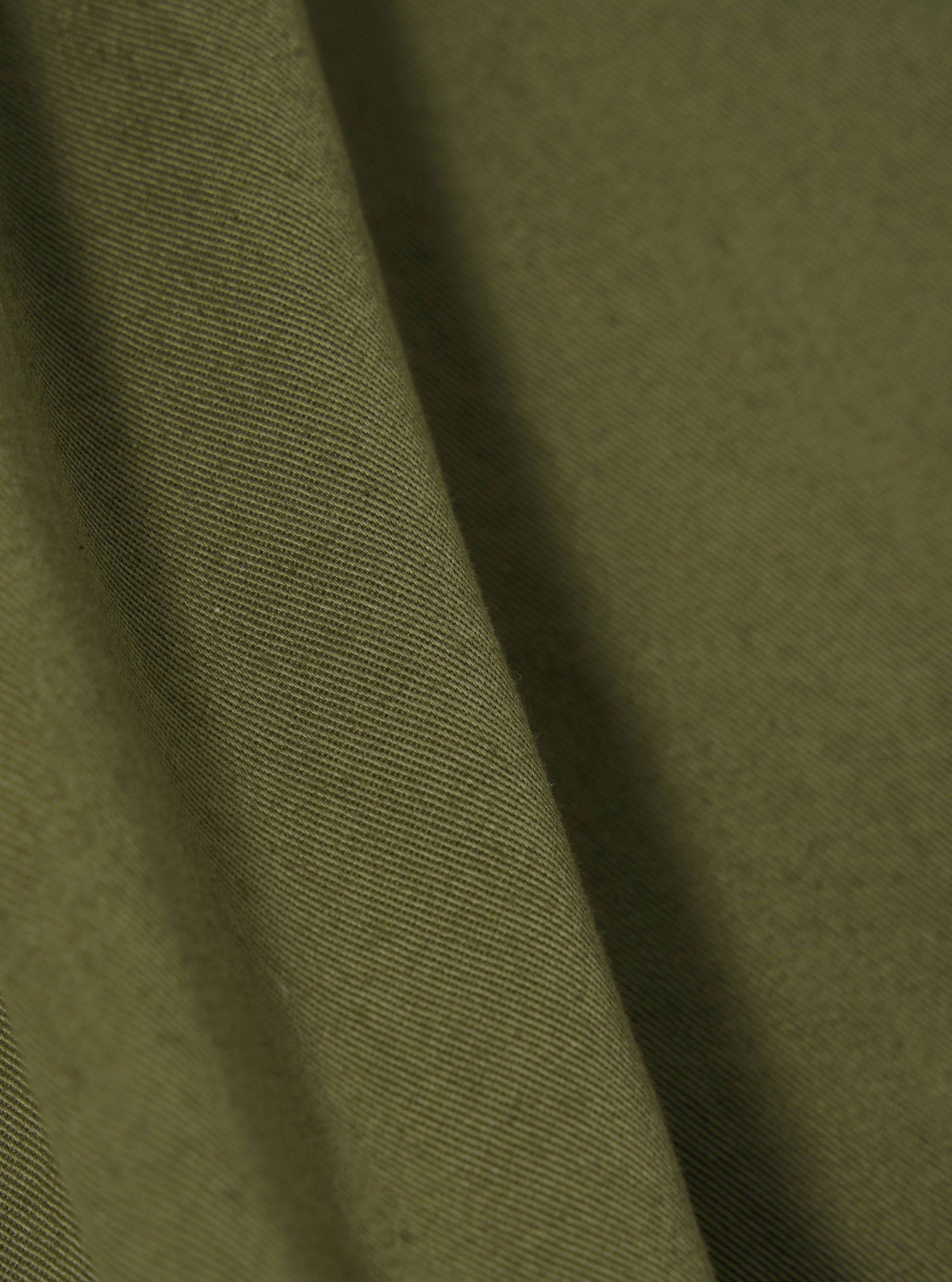 A close-up swatch image of the Light Olive Twill Beach Short fabric. The image focuses on the light olive green cotton twill material, highlighting its diagonal weave texture and consistent color. The background is a plain white.