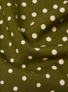 Close-up of a Green Dot Print Short Scarf. The scarf is olive green with white polka dots. The fabric is draped to show texture.