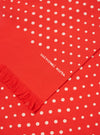 Close-up of an Orange Dot Print Short Scarf. The scarf is red with white polka dots and a fringed edge. The words 'universal works' are printed on the scarf.