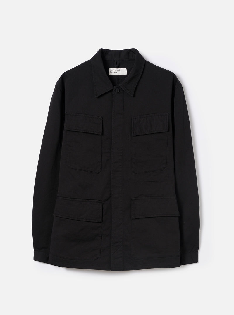 Front view of the Black Twill MW Fatigue Jacket laid flat against a plain white background. The jacket features four front flap pockets, a spread collar, a concealed button placket, and shirt-style button cuffs.