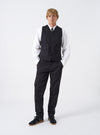 A model wears the Black Twill Field Waistcoat over a shirt in a studio setting against a plain background. The front shot showcases the sleeveless design, V-neck collar, full zip fastening, and front flap pockets.