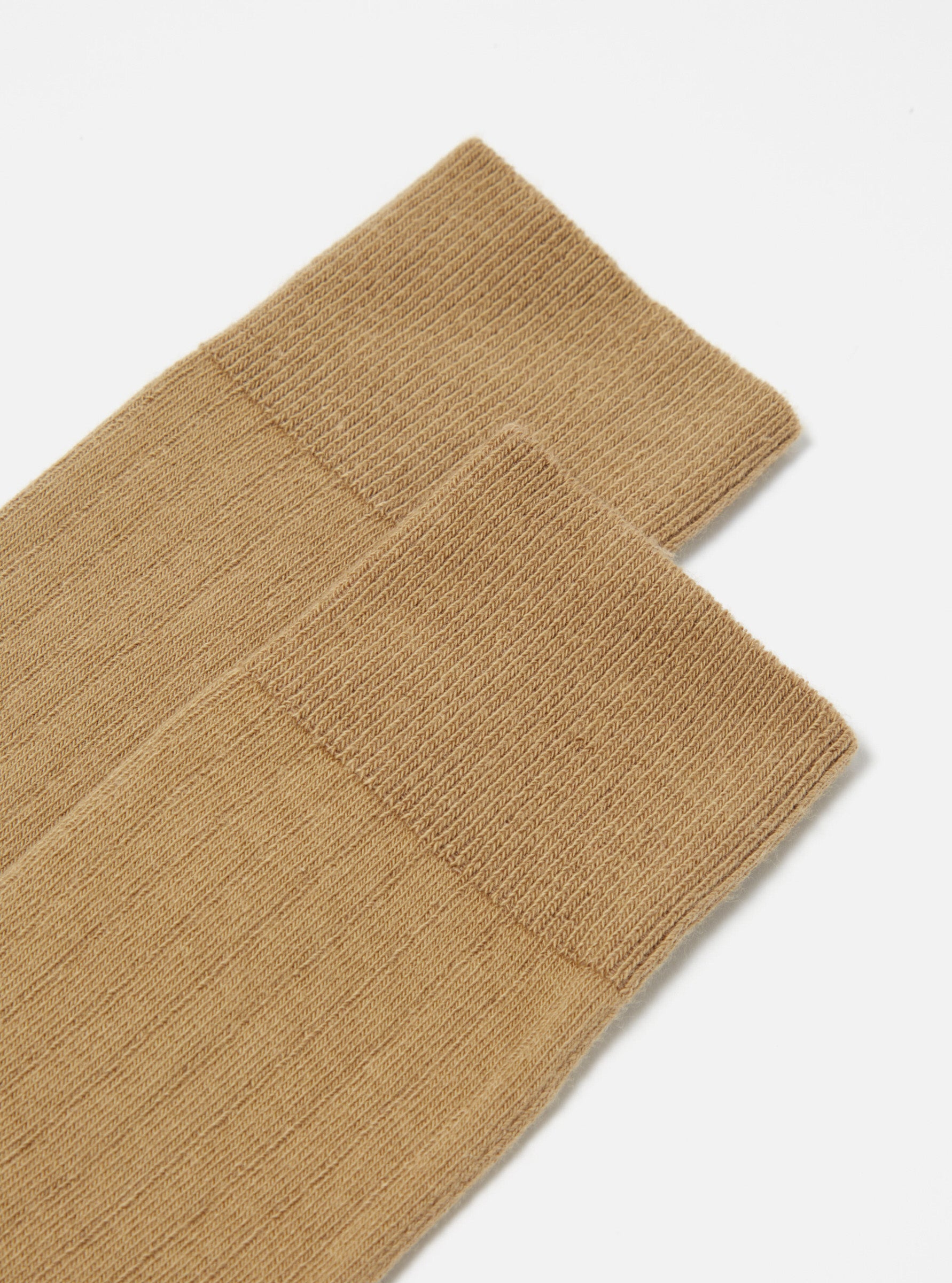 Close-up of Cumin Rib Knit Modal Sock on a white surface. The sock has a ribbed texture and a comfortable fit. The image is well-lit and focuses on the sock's details.