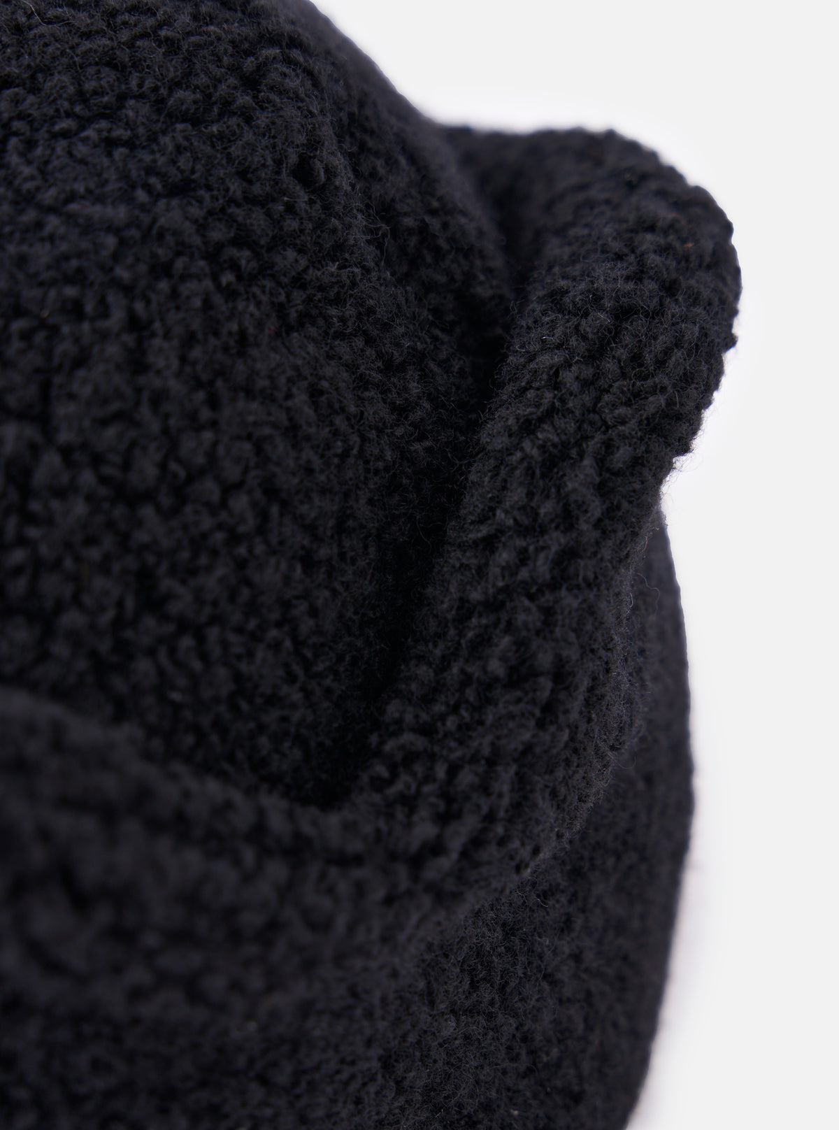 Close-up of the cableami® Black Recycled Wool Flight Watch Cap, showing the texture of the wool. The cap is on a white background.