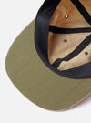 The cableami Beige/Olive Cotton/Nylon B.B Cap is shown in a detail view from the side against a plain white background. The image highlights the six-panel construction, the flat peak, and the tonal eyelets. The fabric is a smooth beige and olive green cotton-nylon blend.