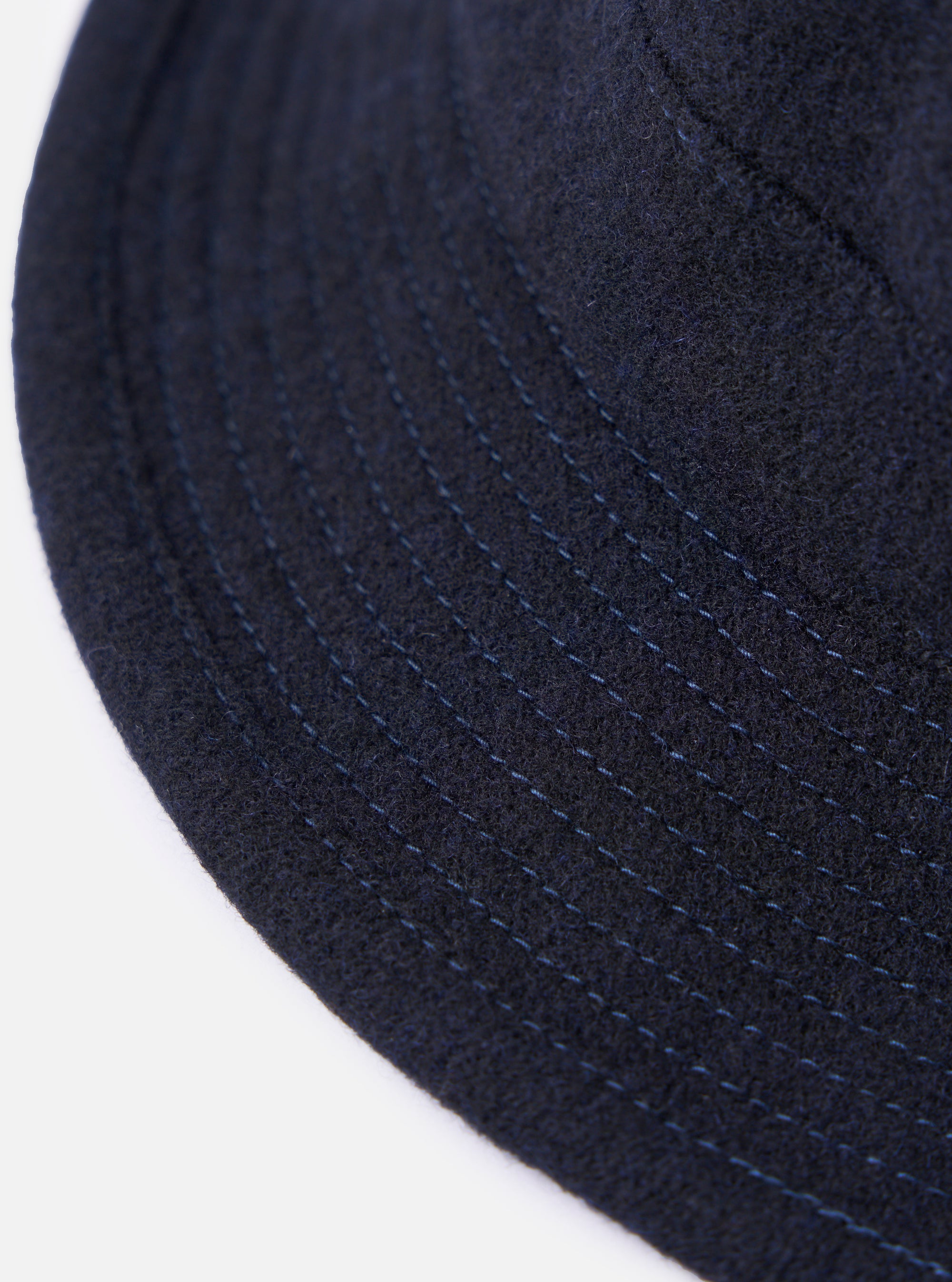 Close-up of the cableami® Navy Recycled Wool Army Hat. The hat is navy blue with subtle stitching, made of recycled wool. Shot on a white background.