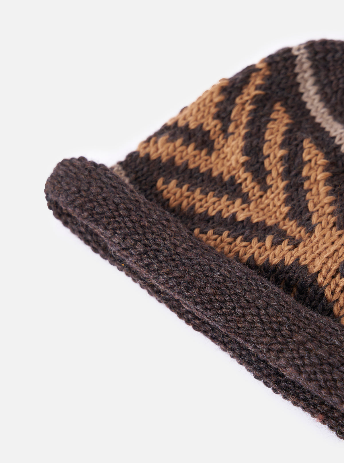 A close up image of the cableami® Brown Wool Jacquard Watch Cap on a white background. Only half of the hat is displayed, emphasising the fine detail of the knit and its orange arrow pattern.
