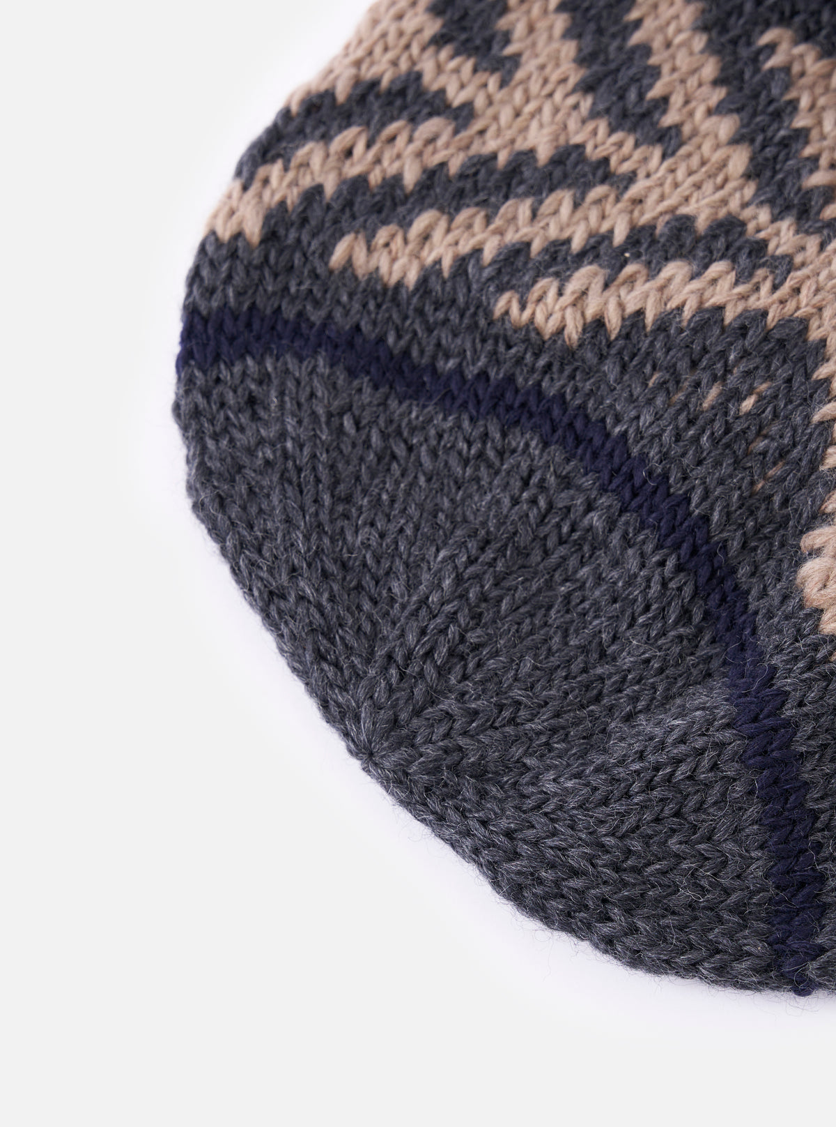 Close-up of the cableami® Grey Wool Jacquard Watch Cap on a white background. The cap features a grey and beige patterned knit with a navy stripe.