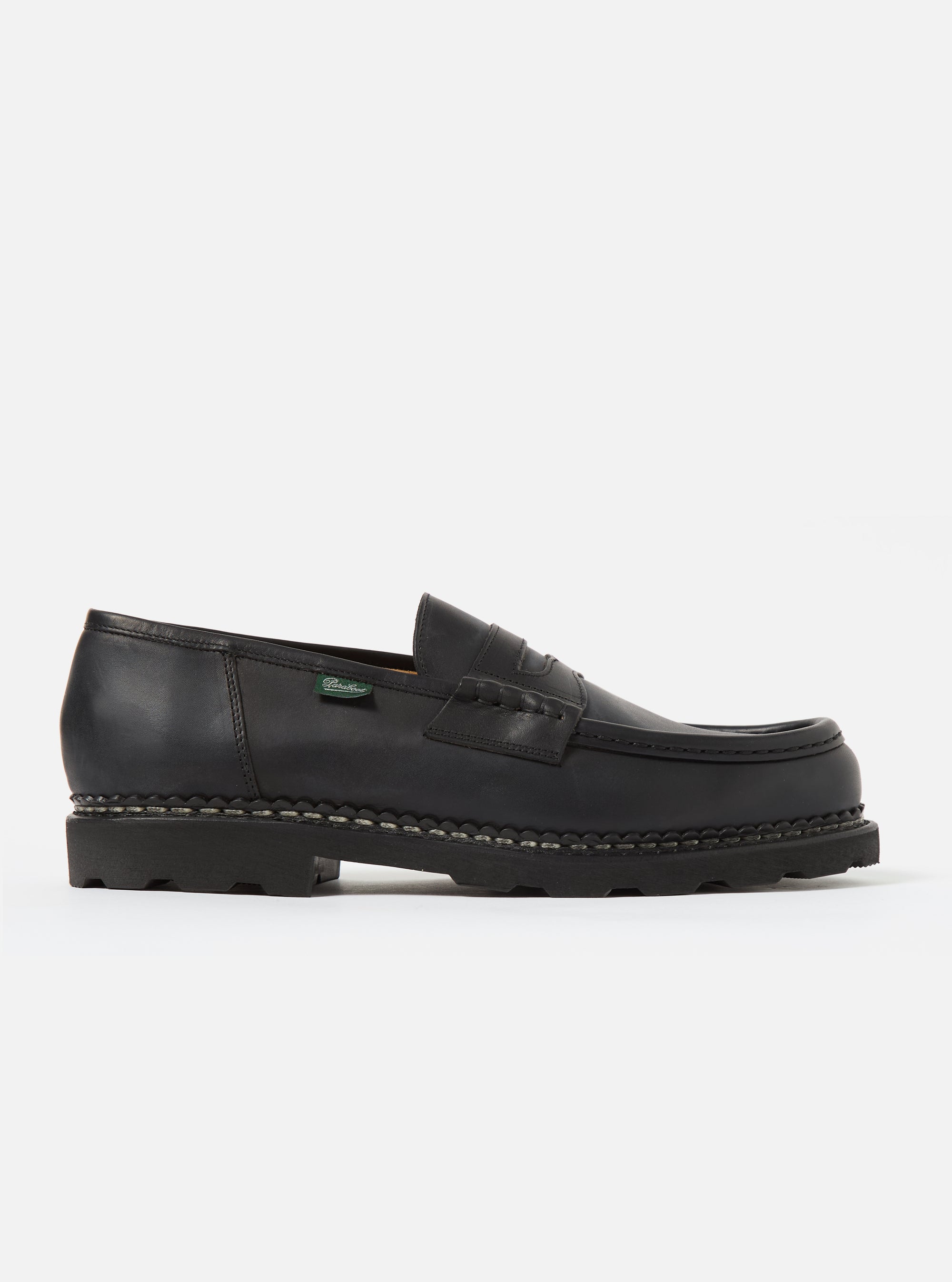 Studio shot of a Paraboot Black Leather Reims Marche shoe. The black leather loafer has a thick sole. Clean white background.