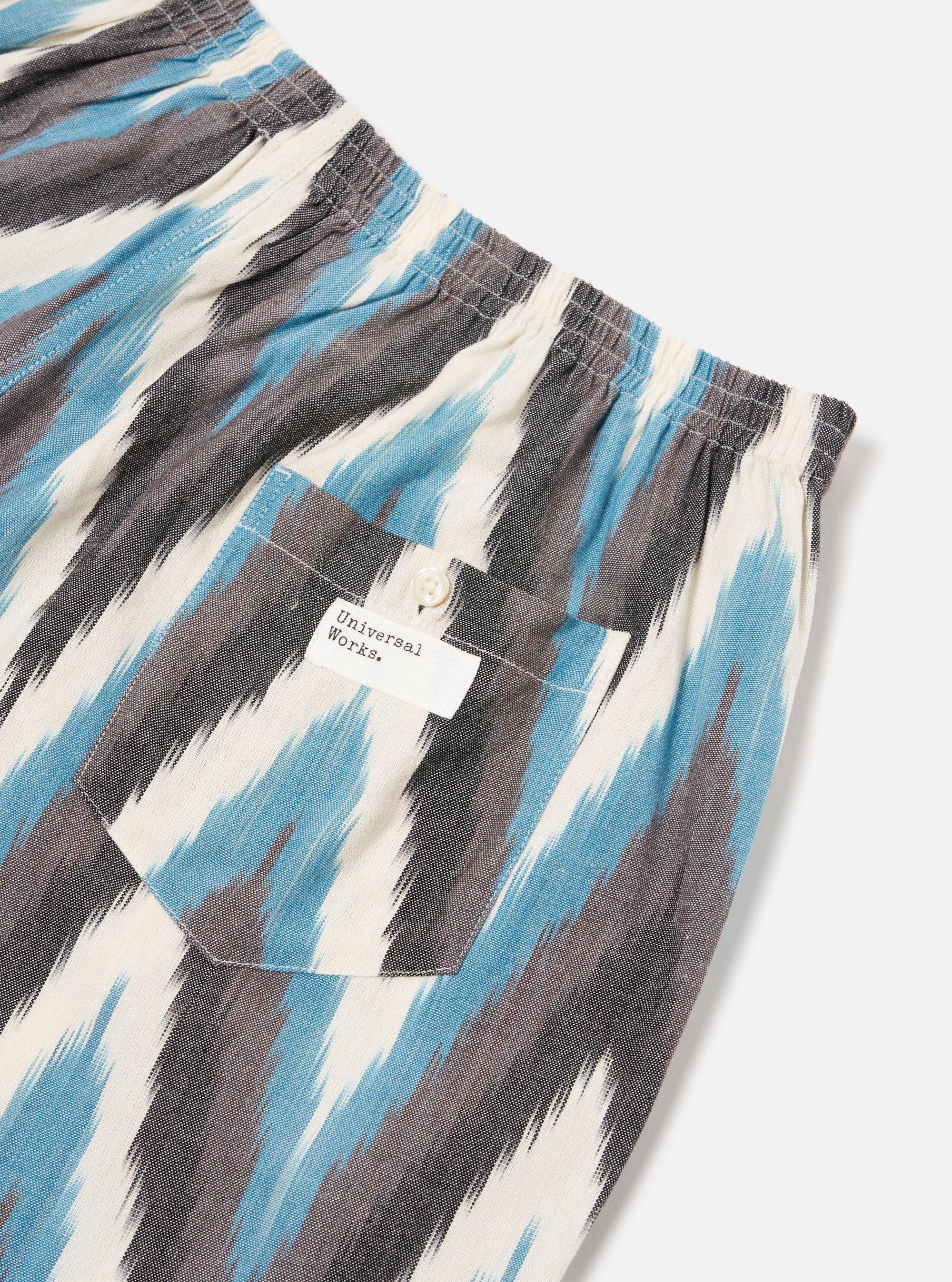Close-up of Ecru Ikat II Cotton Boxer Short on a white background. Features blue, grey, and white ikat pattern, elastic waistband, and back pocket with button.