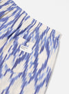 Close-up of Ecru Ikat I Cotton Boxer Short on a white surface. Features blue ikat pattern, elastic waist, and pocket with button. Casual and comfortable.