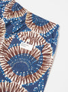 Close-up of the Navy Hokkoh Print Boxer Short on a white surface. The shorts feature a blue and brown pattern and a pocket with a 'Universal Works' label.