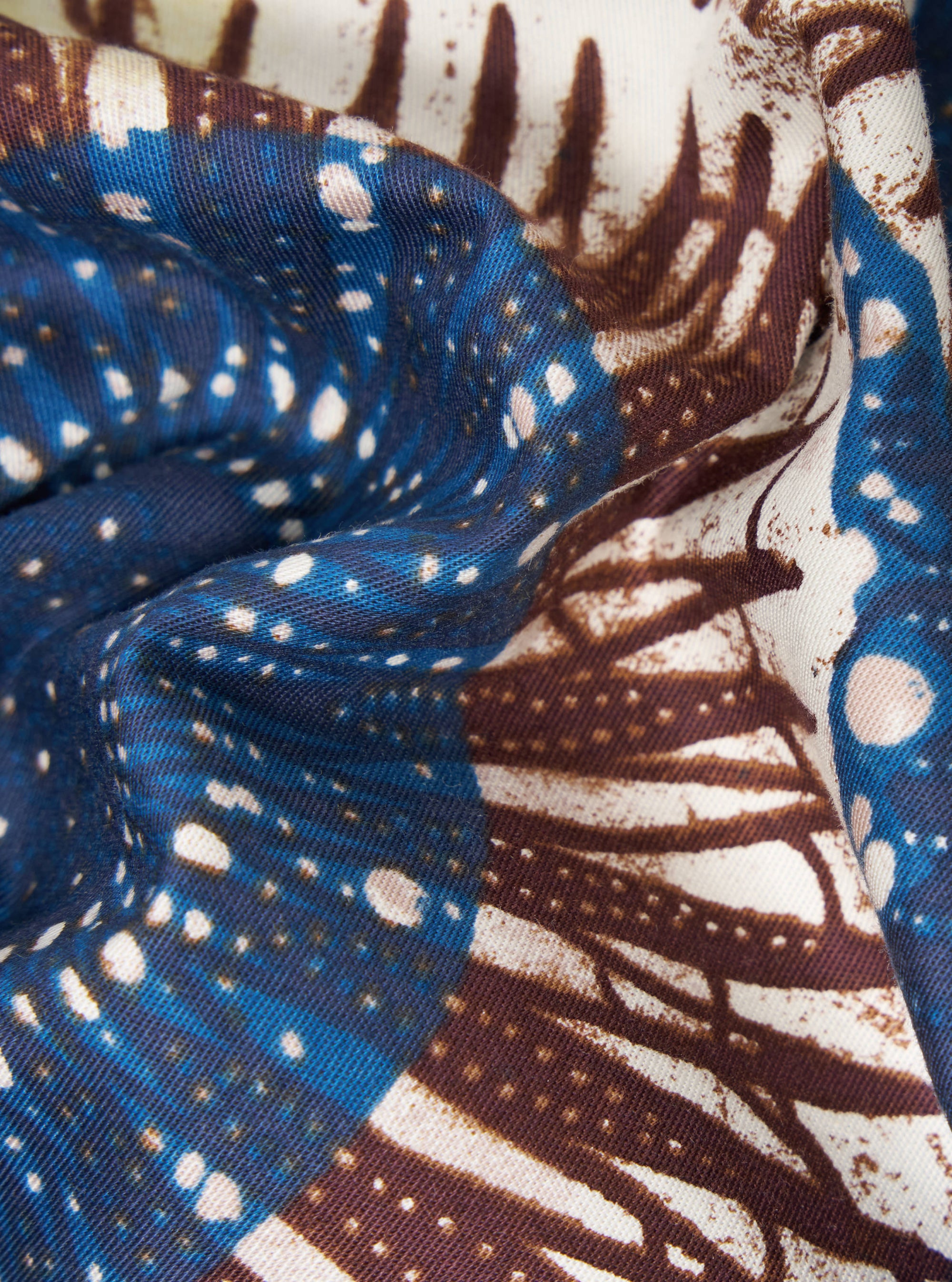 Close-up of the Navy Hokkoh Print Boxer Short fabric. Features a blue, brown, and white pattern. The material is folded, showcasing its texture and design.