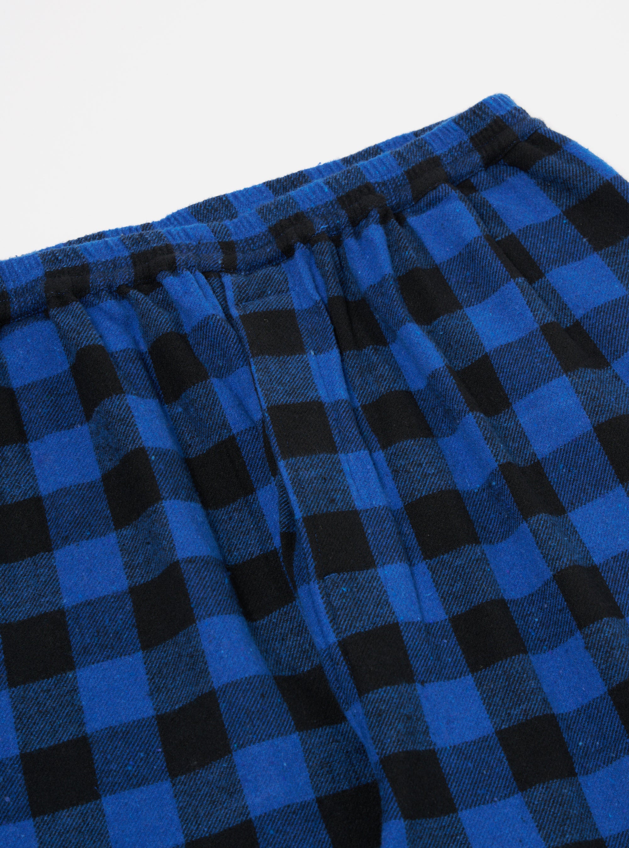 Close-up of the Blue Brushed Bold Gingham Pyjama Pant on a white background. The brushed fabric has a blue and black gingham pattern and an elastic waist.