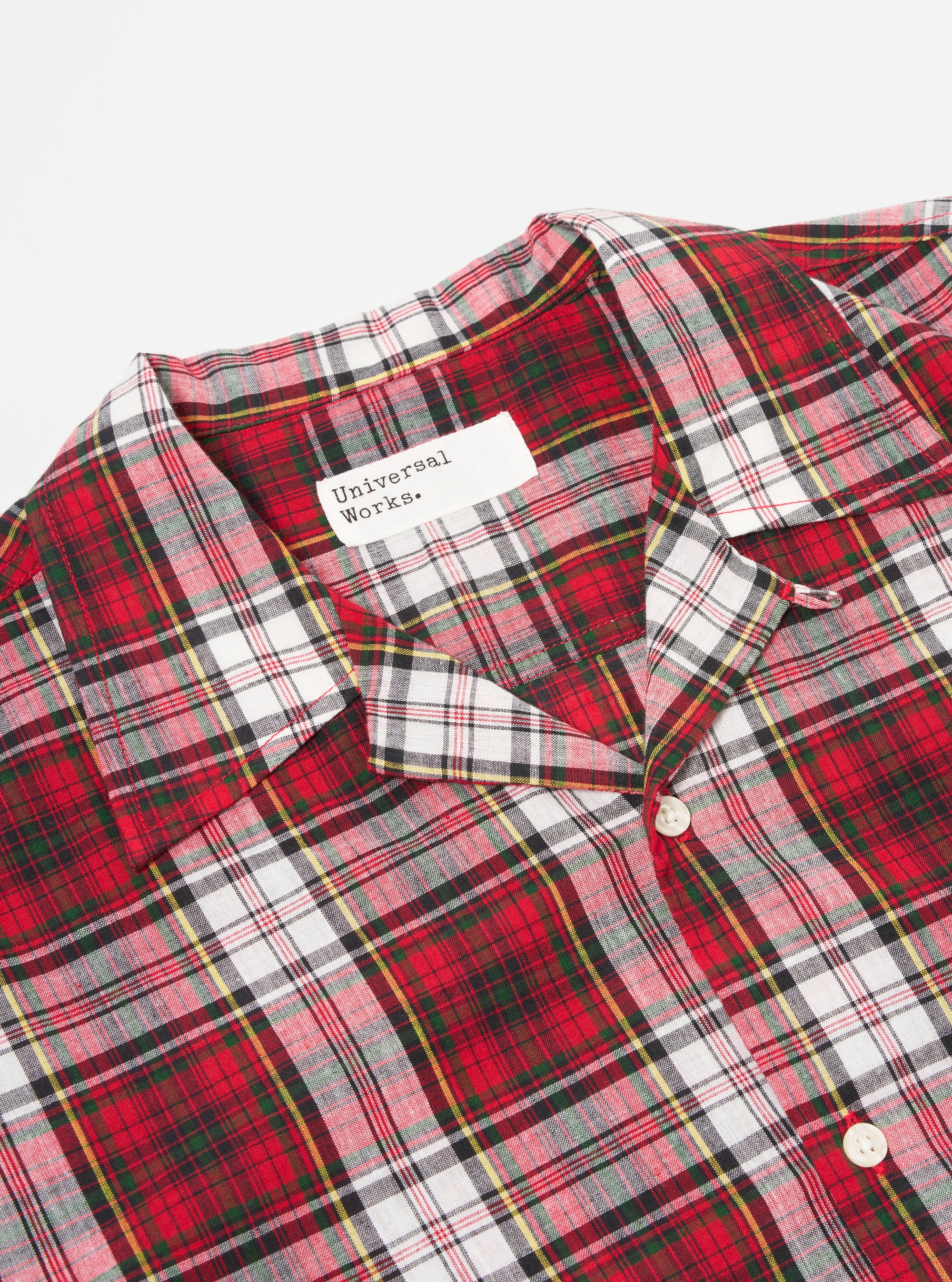 Close-up of the Red Madras Check Short Pyjama Set top on a white surface. The red, white, green, and yellow plaid shirt has a collar and buttons.