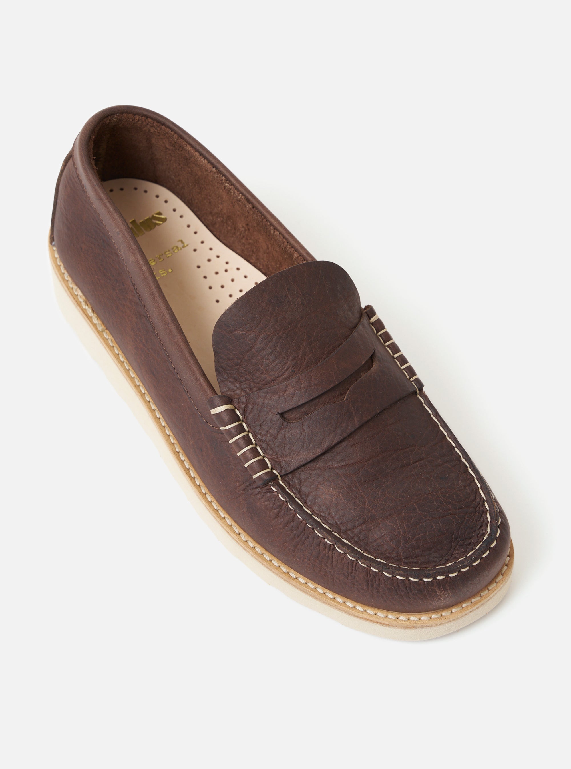 Studio shot of a Zardus for Universal Works Brown Leather Reggie Loafer. The brown leather shoe has white stitching and a light sole. The background is a plain white.