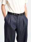 A model wears a Black Canvas O Ring Belt with dark denim pants and a cream t-shirt. The background is a clean white. The belt is black canvas with a silver O ring.