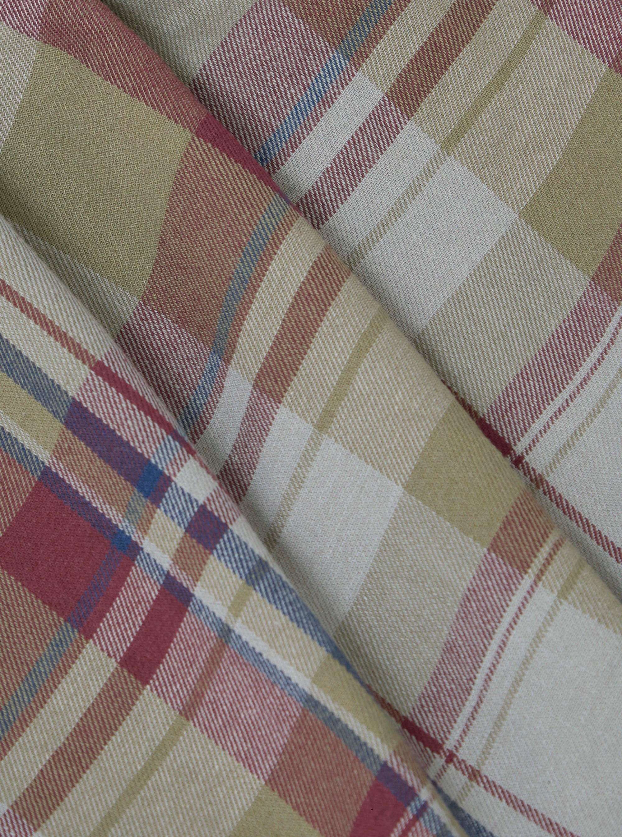 Close-up of folded Multi Kip Check 3 Pack Boxer Short fabric. Features a beige, red, and blue plaid pattern. The material is neatly arranged on a flat surface.