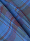 Close-up of the Multi Kip Check 3 Pack Boxer Short fabric. The blue, brown, and green plaid material is folded on a plain surface, showing the texture and pattern.