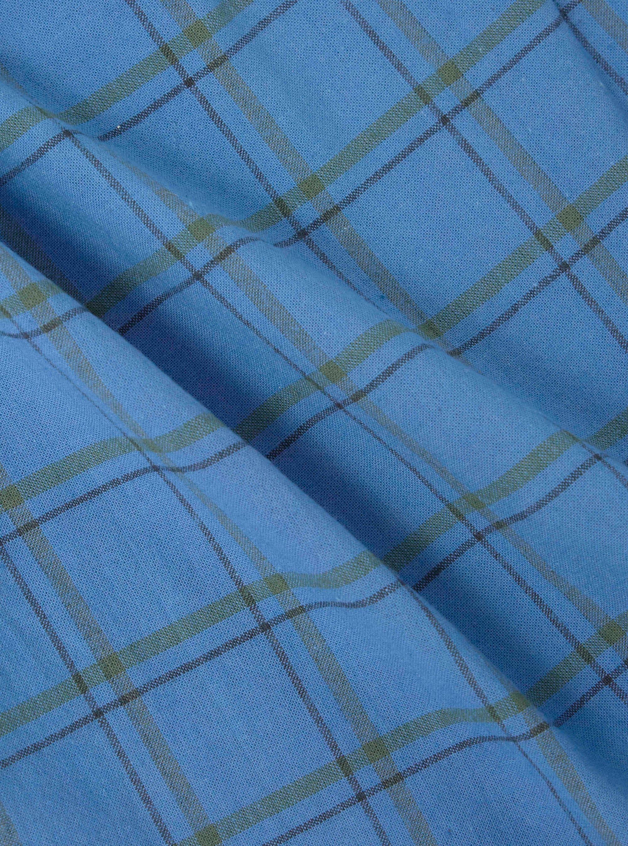 Close-up of blue plaid fabric, part of the Multi PJ Plaid 3 Pack Boxer Short collection. Soft cotton material with green and black lines. Shot on a flat surface.