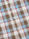 Close-up of the Blue/Brown Check 3 Long Pyjama Set fabric. Features a blue, brown, pink, and white plaid pattern with button details. The fabric is neatly arranged on a flat surface.