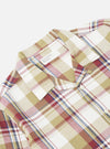 Close-up of the Red/Brown Kip Check Long Pyjama Set. The cotton fabric features a red, brown, and blue plaid pattern on a white background. The set is neatly folded on a white surface.