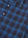 Close-up of the Navy/Blue Check Long Pyjama Set top. The blue and navy check pattern is visible, along with the shirt pocket and buttons. The background is a plain surface.