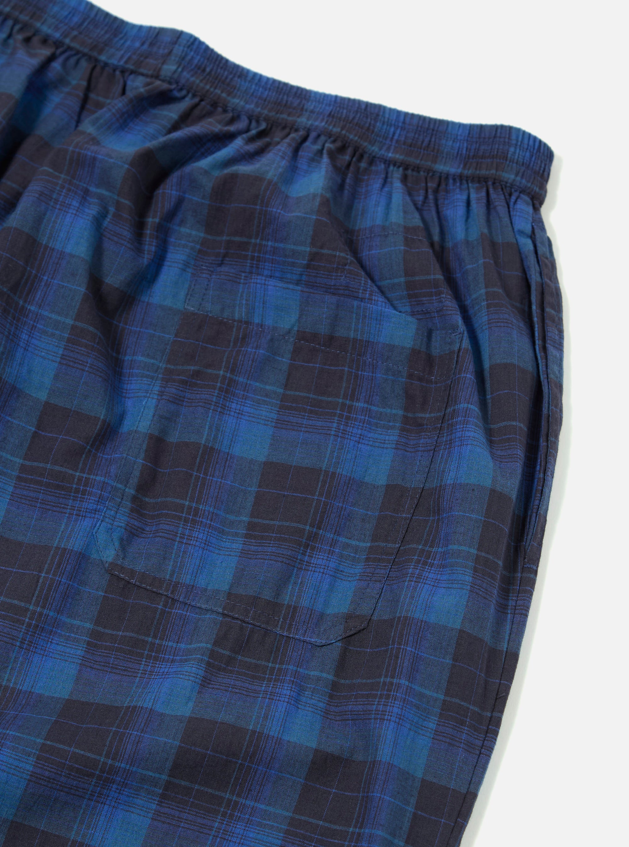 Close-up of the Navy/Blue Check Pyjama Pant on a white surface. The fabric is a soft, brushed cotton with a classic check pattern. Features an elastic waistband and a back pocket.