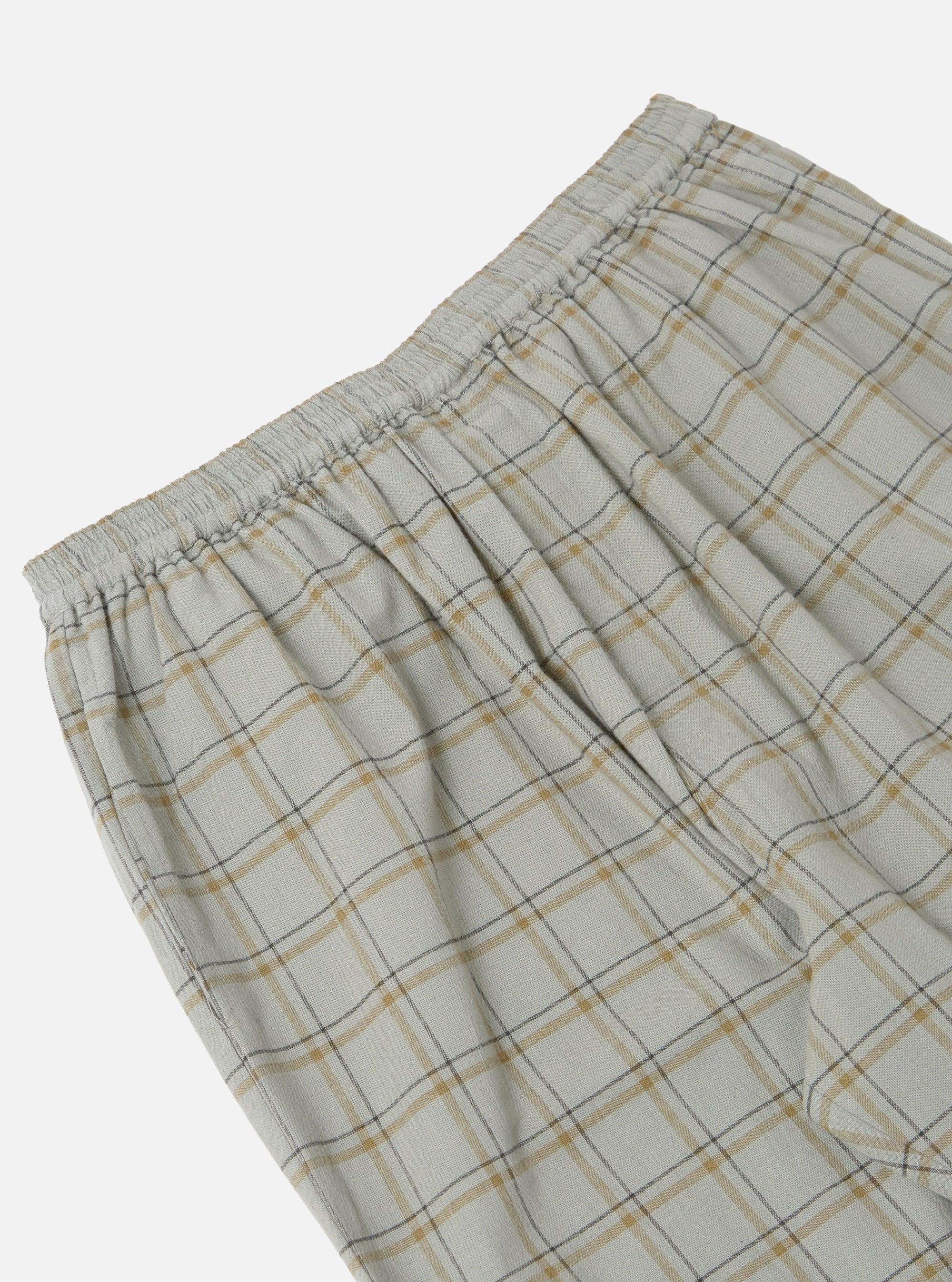 Close-up of the Green PJ Plaid Pyjama Pant on a white background. The pajama pant has a plaid pattern with green, yellow, and gray lines. The waist is elastic.