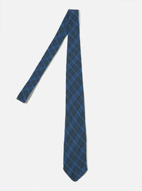 The Navy Picnic Plaid Tie on a white surface. The tie is blue with a dark green plaid pattern. The tie is laying diagonally.