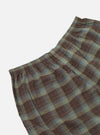 Close-up of Green Patchwork Madras Boxer Short on a white background. The fabric is a brown and green plaid with an elastic waistband.