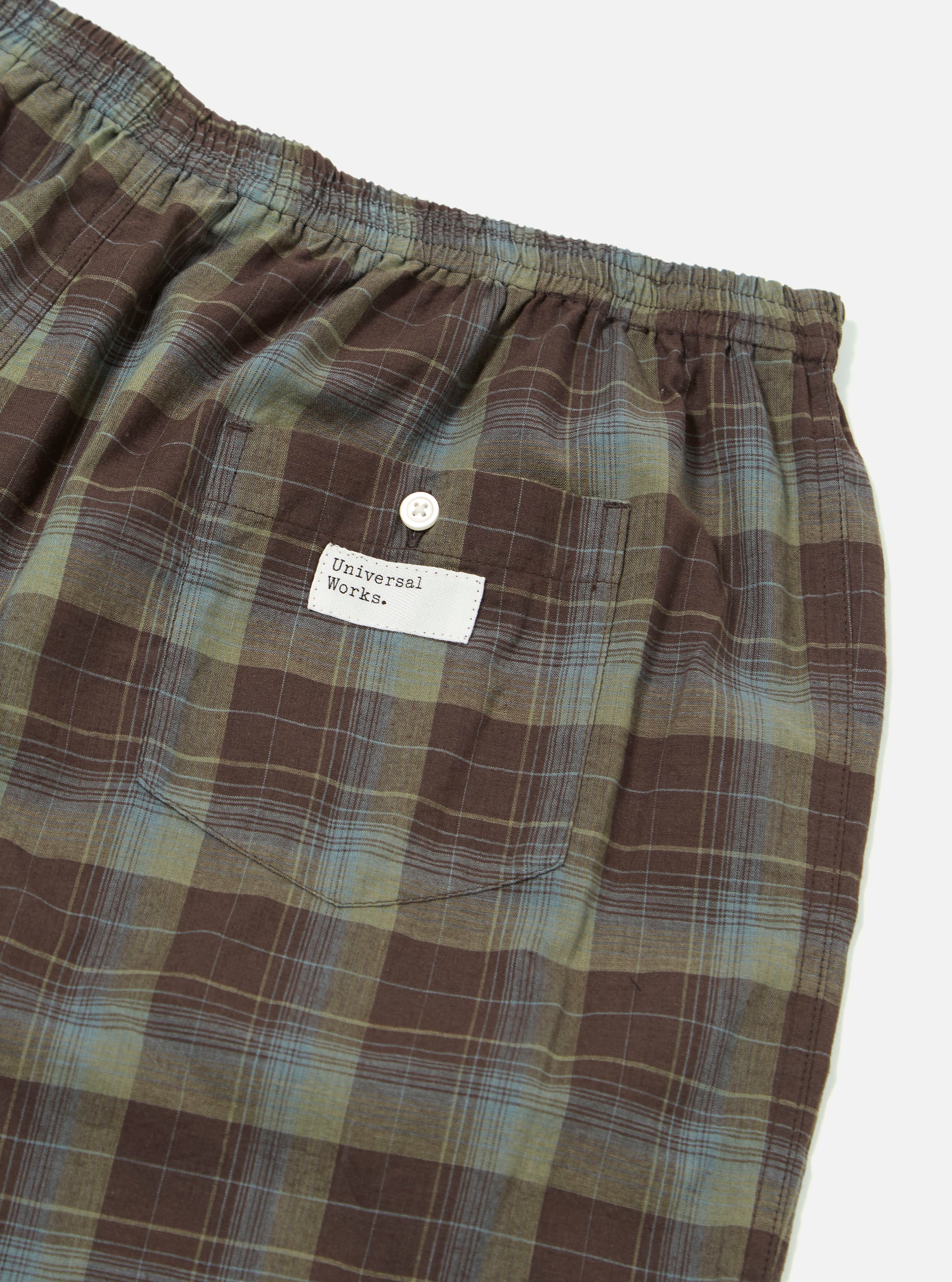 Close-up of the Green Patchwork Madras Boxer Short on a white background. The shorts feature a brown, green, and blue plaid pattern with an elastic waistband and a back pocket.