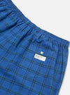 Close-up of the Navy PJ Plaid Boxer Short on a white background. The blue plaid boxer shorts have an elastic waist and a pocket with a button.