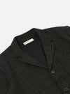 Close-up of the Black Salt N Pepper Tweed Three Button Jacket on a white background. The tweed material has flecks of color. The jacket has a black lining.