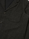 Close up of the Black Salt N Pepper Tweed Three Button Jacket. The tweed material is visible, along with the buttons and pocket. The background is a plain white.