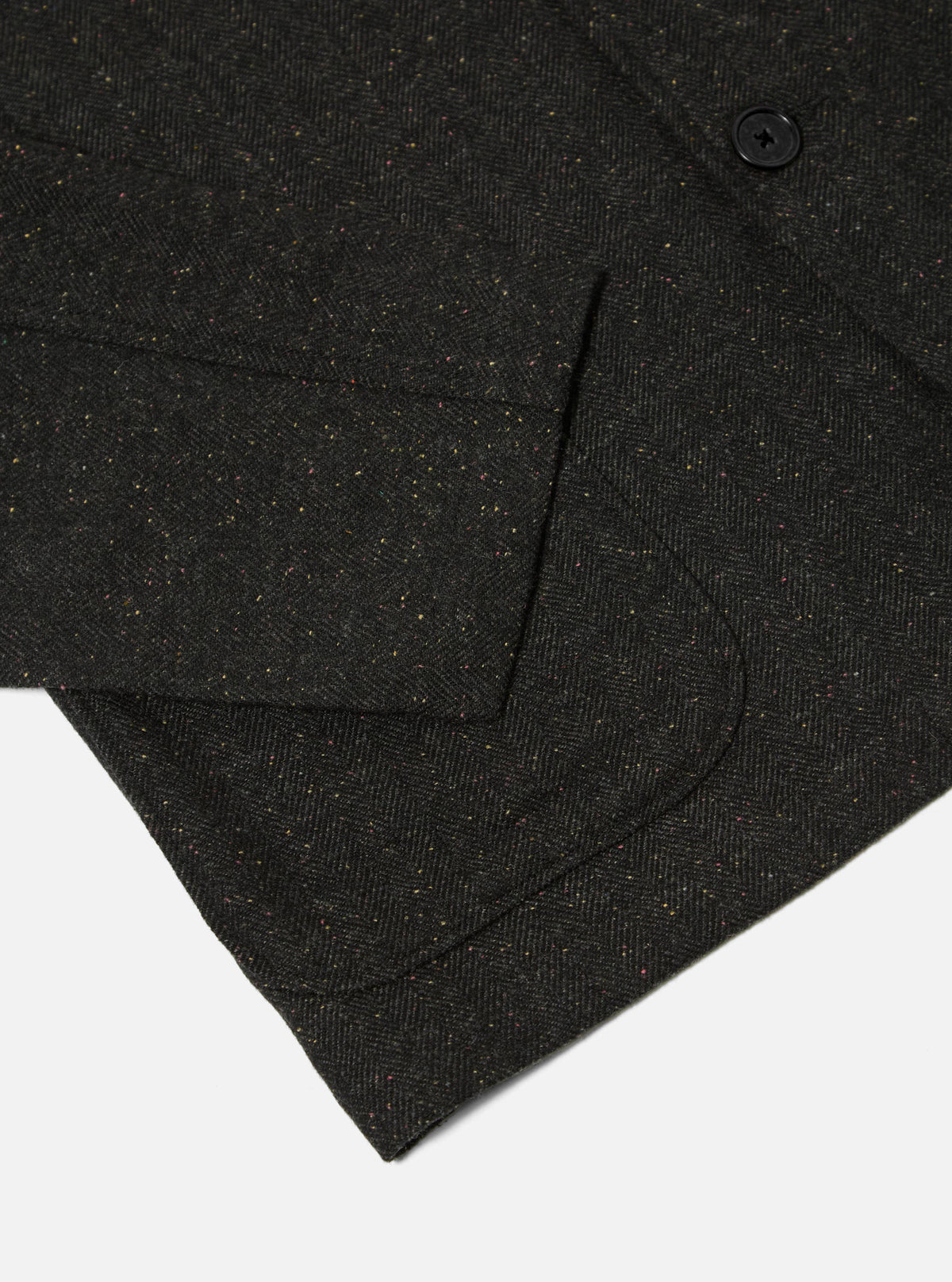 Close up of the Black Salt N Pepper Tweed Three Button Jacket showing the tweed texture and pocket detail. The jacket is on a white background.