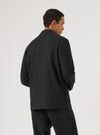 A man models the Black Salt N Pepper Tweed Three Button Jacket against a white backdrop. The jacket has a tailored fit and visible tweed texture.