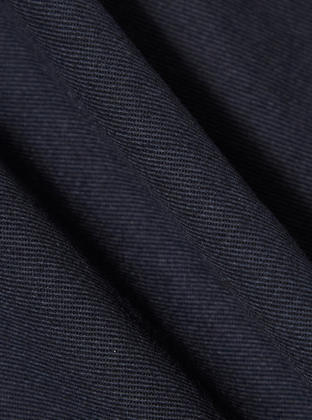Close-up of the navy twill fabric of the Navy Works Twill Station Waistcoat. The durable material is shown with subtle folds, highlighting its texture and quality.