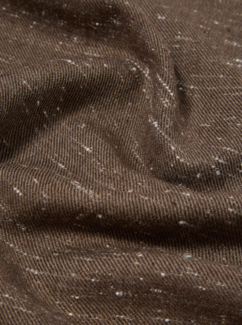 Close-up of a textured brown wool scarf with subtle white flecks. The fabric is draped to show its soft texture. Perfect for adding warmth and style.