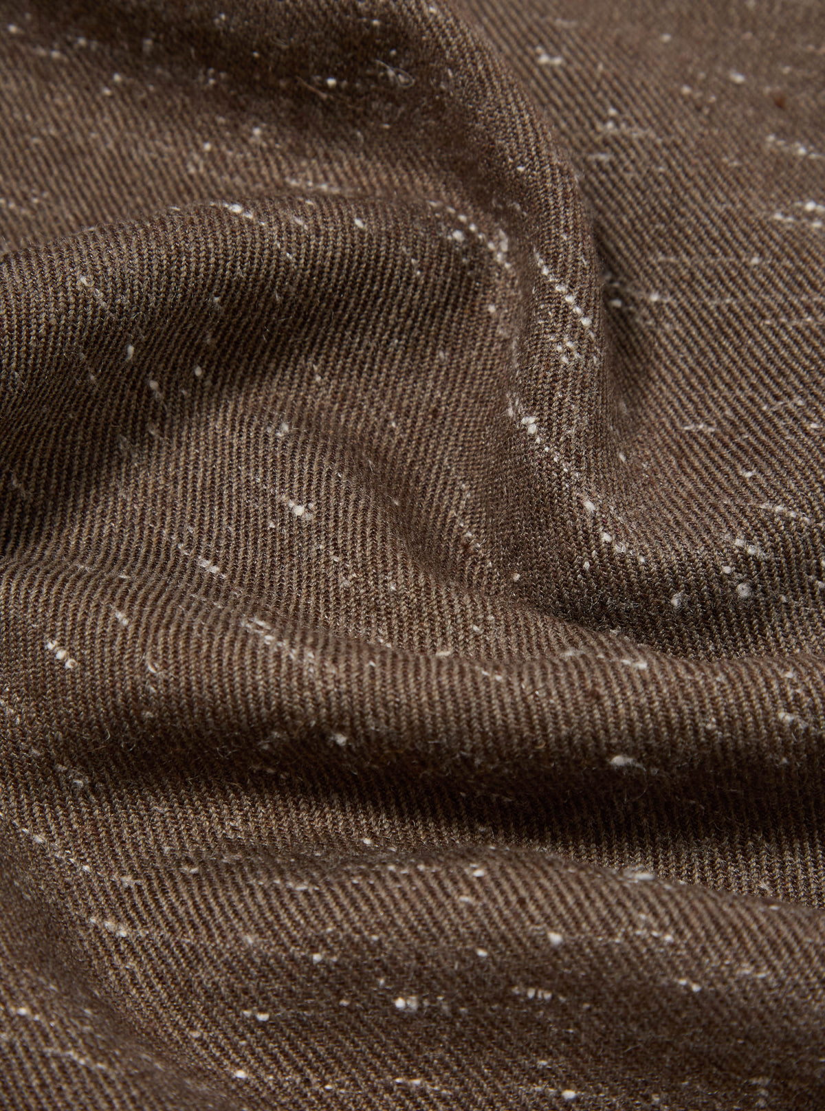 Close-up of a textured brown wool scarf with subtle white flecks. The fabric is draped to show its soft texture. Perfect for adding warmth and style.