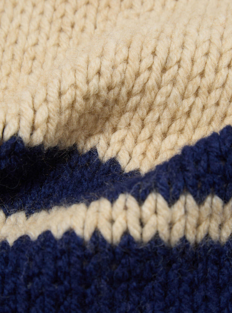 Close-up of the Sand Chunky Knit Stripe Lenny Scarf. Features a chunky knit in sand and navy stripes. The scarf is soft and warm, perfect for cold weather.