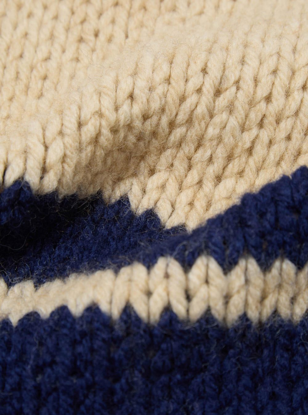 Close-up of the Sand Chunky Knit Stripe Lenny Scarf. Features a chunky knit in sand and navy stripes. The scarf is soft and warm, perfect for cold weather.