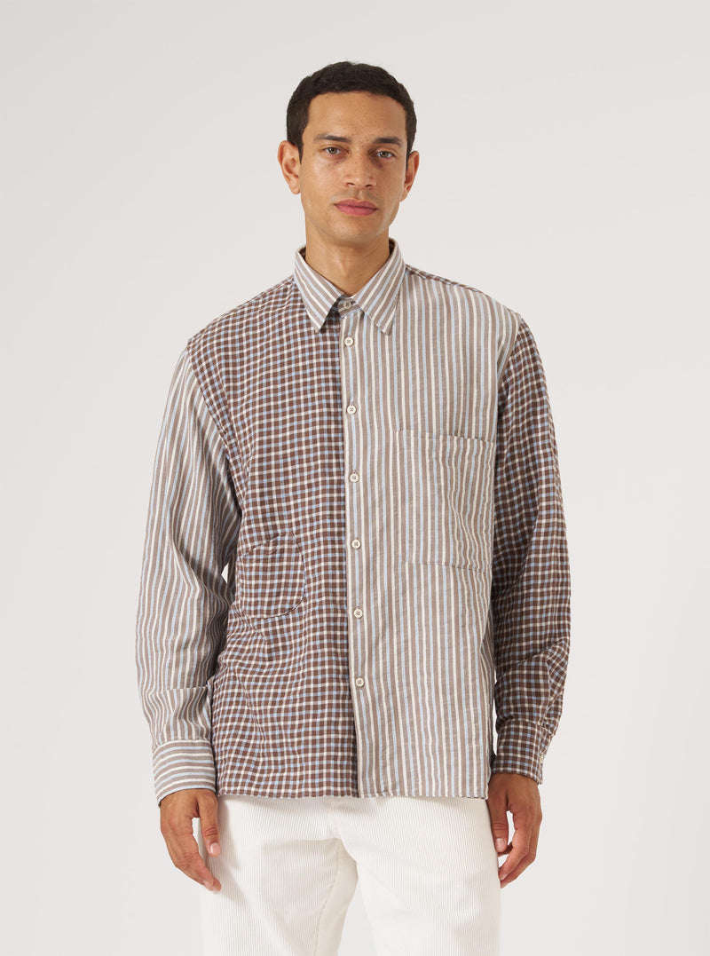A model wears the Brown Madison Check/Stripe Station Shirt. The shirt is half brown check, half brown stripe. Shot in front of a white background.