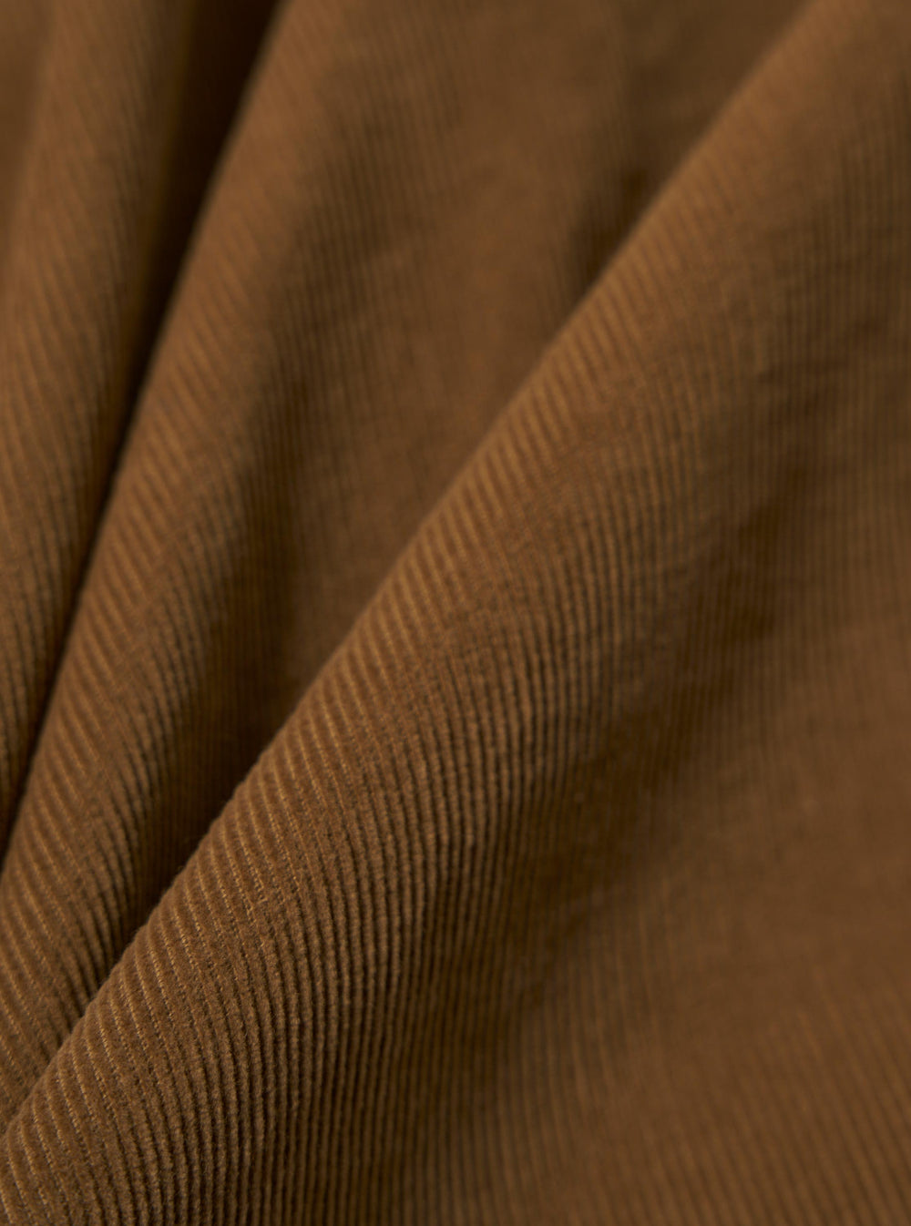 Close-up of the Khaki Fine Cord Kyoto Work Jacket fabric. The fine corduroy texture is visible in a warm khaki color. The material is draped to show its texture.