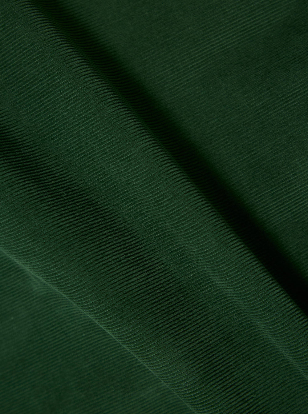 Close-up of the green fine cord material of the Bakers Overshirt. The fabric is draped to show texture and detail.