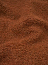 A macro close-up fabric swatch image of the Cumin Alvar Fleece Lancaster Jacket displayed against a plain background. The shot focuses on the textured, plush cumin-colored fleece knit, highlighting its rich wool blend structure.