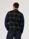 Back view of a man wearing the Grey Moh Check Fleece Button Front Bomber. The bomber has a grey and black check pattern on the body and blue sleeves. Shot against a white backdrop.