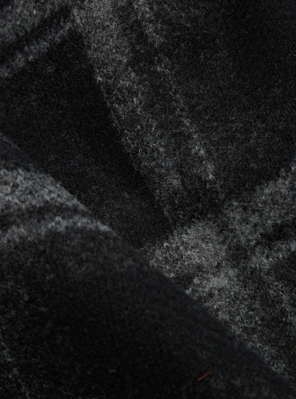 Close-up of the Grey Moh Check Fleece Button Front Bomber, showcasing the soft, textured fleece material with a subtle check pattern. The fabric's folds add depth to the image.