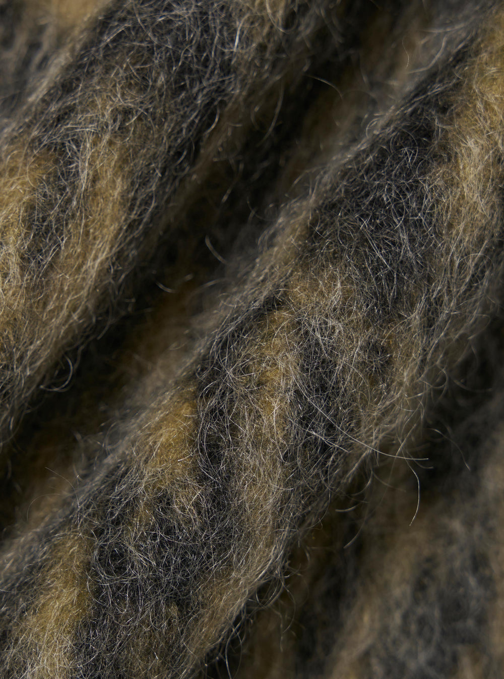 Close-up of the Charcoal Dolce Fleece Zip Gilet, showcasing the soft, textured fleece material in shades of charcoal and brown. The fabric is draped to highlight its plush texture.